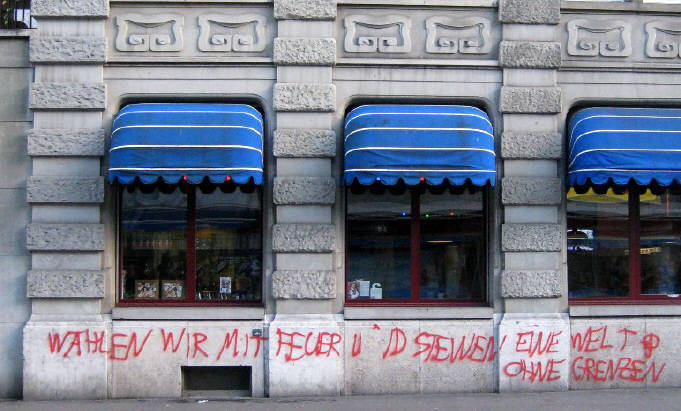 WHLEN WIR MIT FEUER UND STEINEN EINE WELT OHNE GRENZEN. Protestparole in Zrich Schweiz an einer Hauswand. November 2010